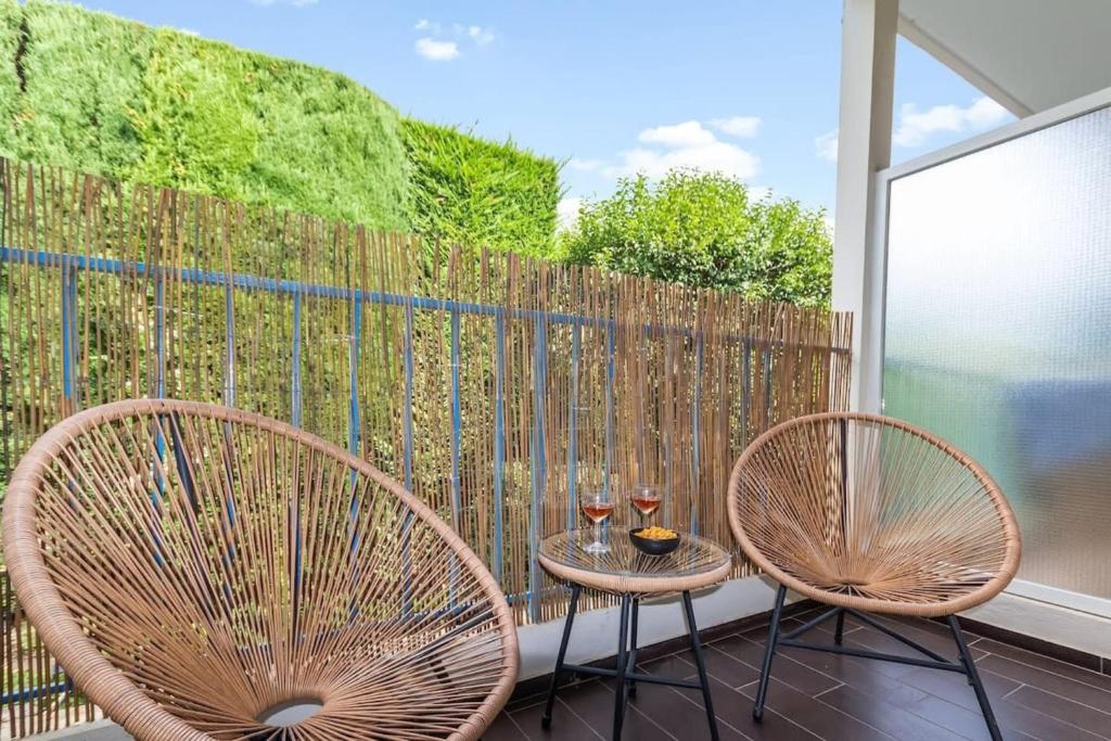 - deux chaises et une table sur un balcon avec des verres à vin dans l'établissement L'Emeraude - Calm - Beach - WIFI, à Antibes