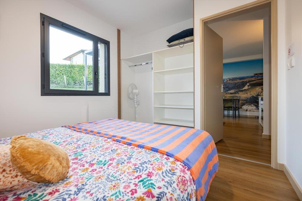 Schlafzimmer mit einem großen Bett, einem Fenster und einer Tür in der Unterkunft Gîte L'escapade dauphinoise 2 chambres parking privé in Beaucroissant