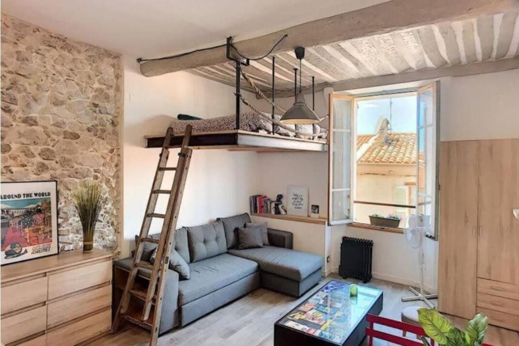 un salon avec un canapé bleu et une échelle dans l'établissement The Massena - Hypercentre - AC - Old Town, à Antibes