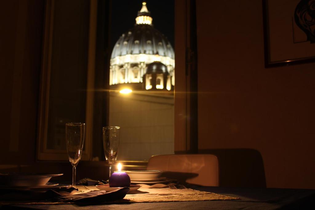 Maison Cavalleggeri في روما: طاولة مع شمعة مضاءة على طاولة مع مبنى