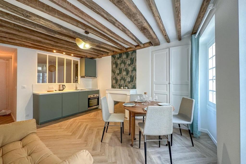 une cuisine et une salle à manger avec une table et des chaises dans l'établissement Flexliving - studio - 3 Portes, à Paris