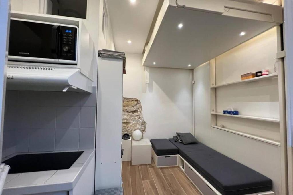 Il comprend une petite cuisine avec un canapé et un four micro-ondes. dans l'établissement Flexliving - Studio - Gérard, à Paris