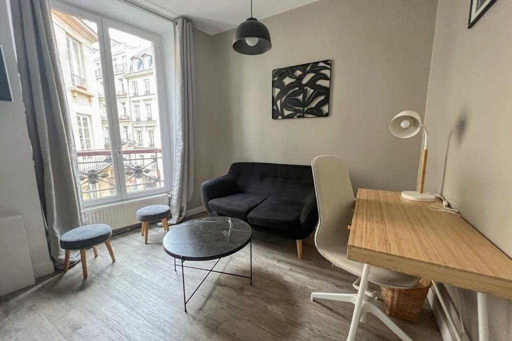 un salon avec un canapé noir et une table dans l'établissement Flexliving - Beautiful 2-room apartment - Chaussée d'Antin - Paris 09, à Paris