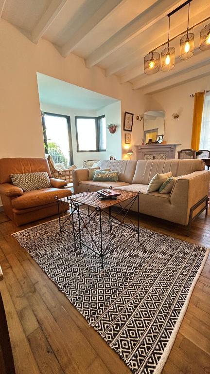 - un salon avec un canapé et une table sur un tapis dans l'établissement La villa Marguerite, face mer avec terrasses, à Concarneau