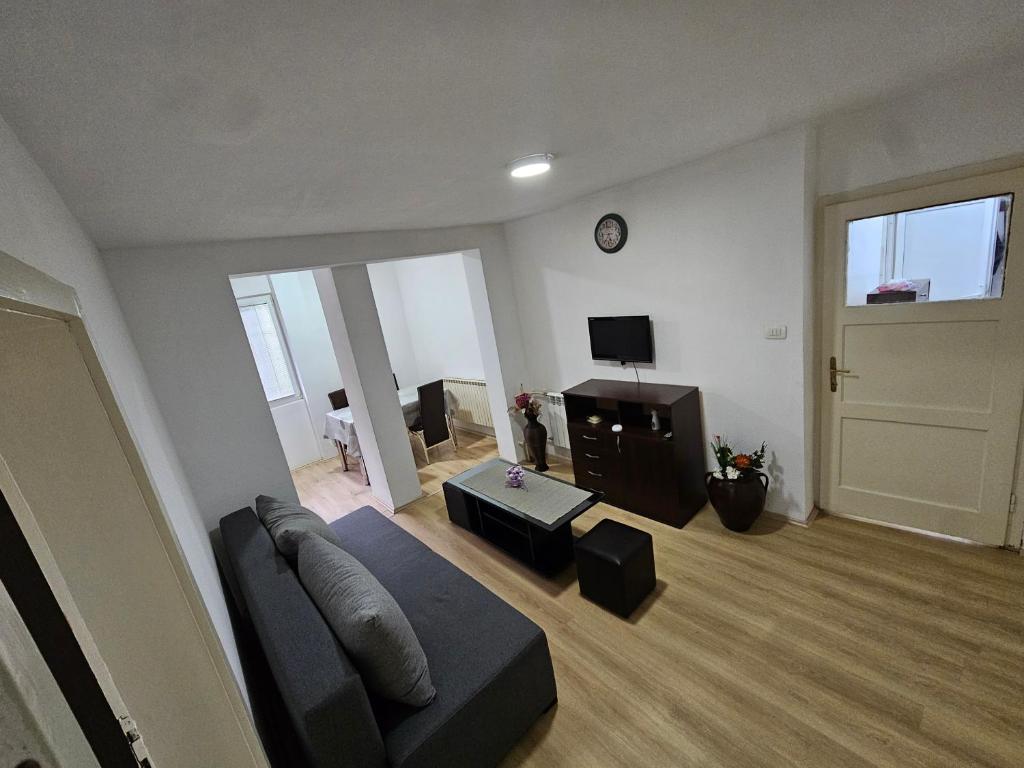 ein Wohnzimmer mit einer blauen Couch und einem Fernseher in der Unterkunft Avtokomanda in Skopje