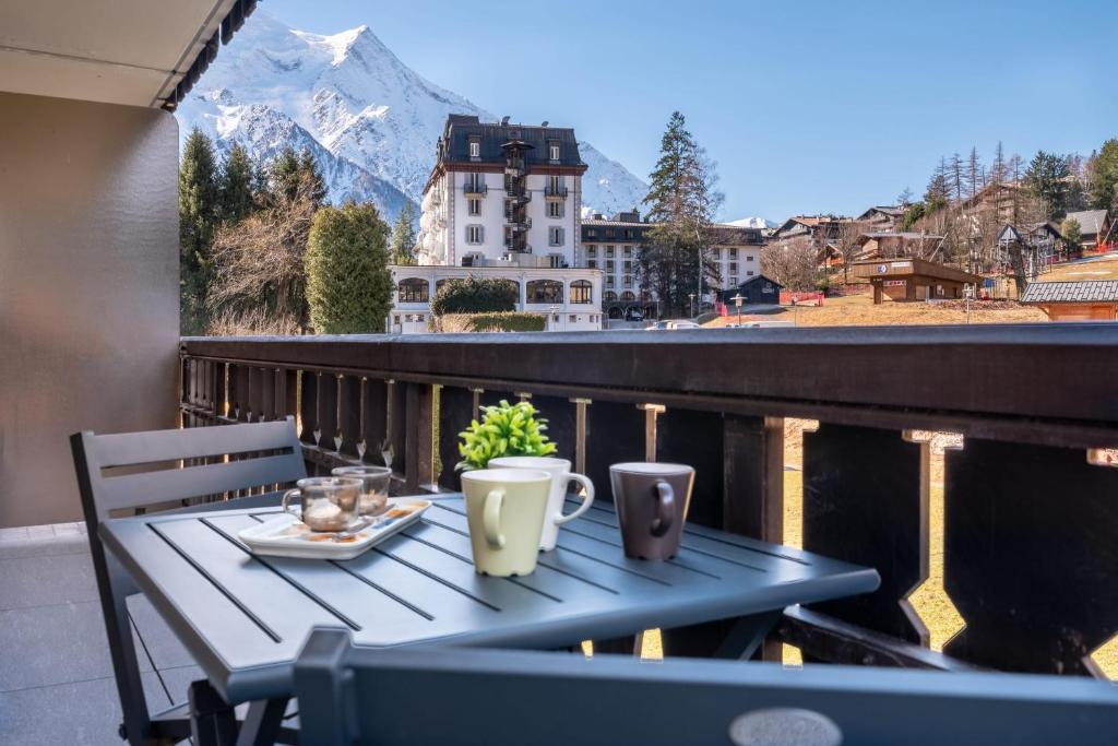 d'une table sur un balcon avec vue sur la montagne. dans l'établissement Appartement des Champs - Welkeys, à Chamonix-Mont-Blanc