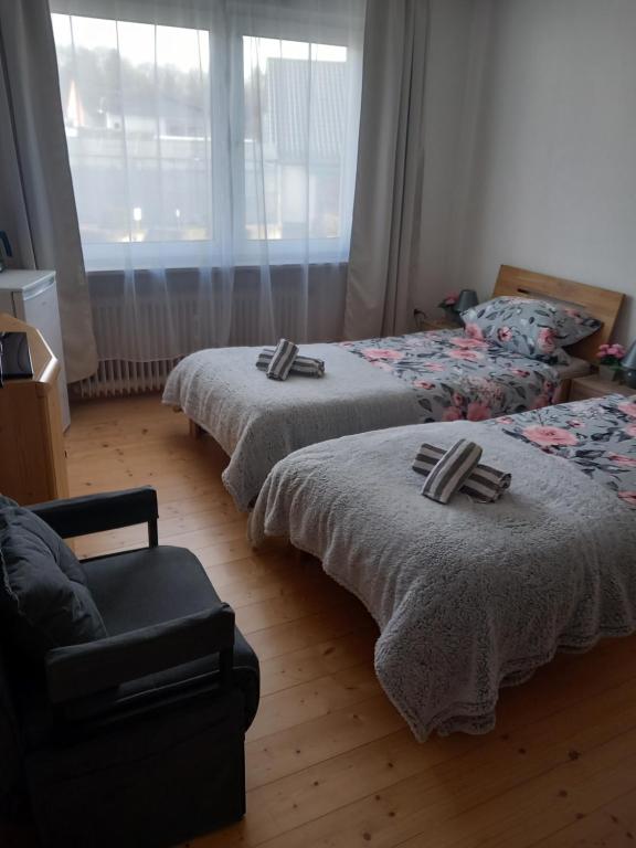 a bedroom with two beds and a couch and a window at Zimmervermietung Pargen in Daun