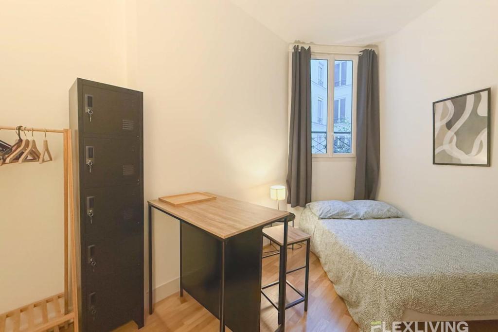 - une chambre avec un lit, un bureau, un lit et une fenêtre dans l'établissement Flexliving - Studio - La Fayette, à Paris