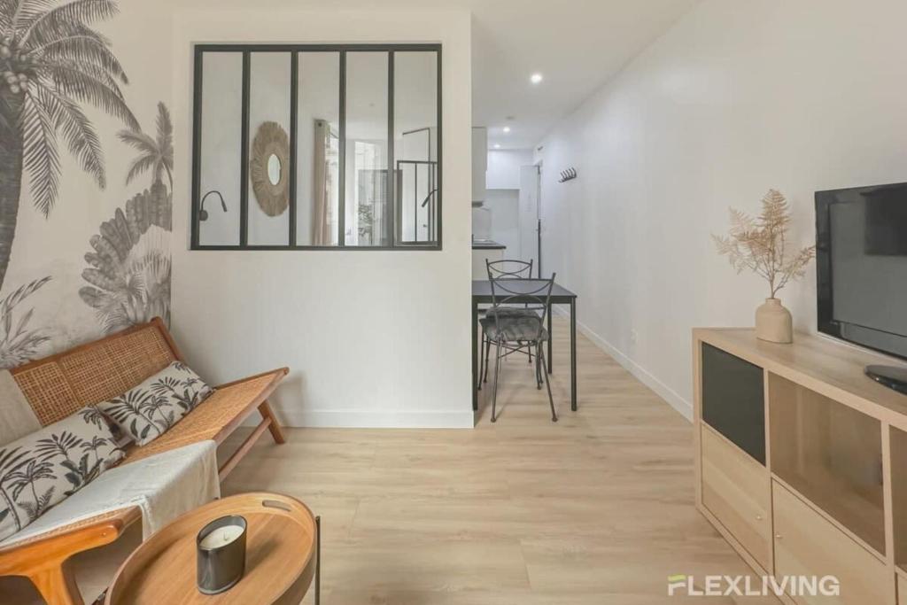 un salon avec un canapé et une télévision dans l'établissement Flexliving - studio - Guénot, à Paris
