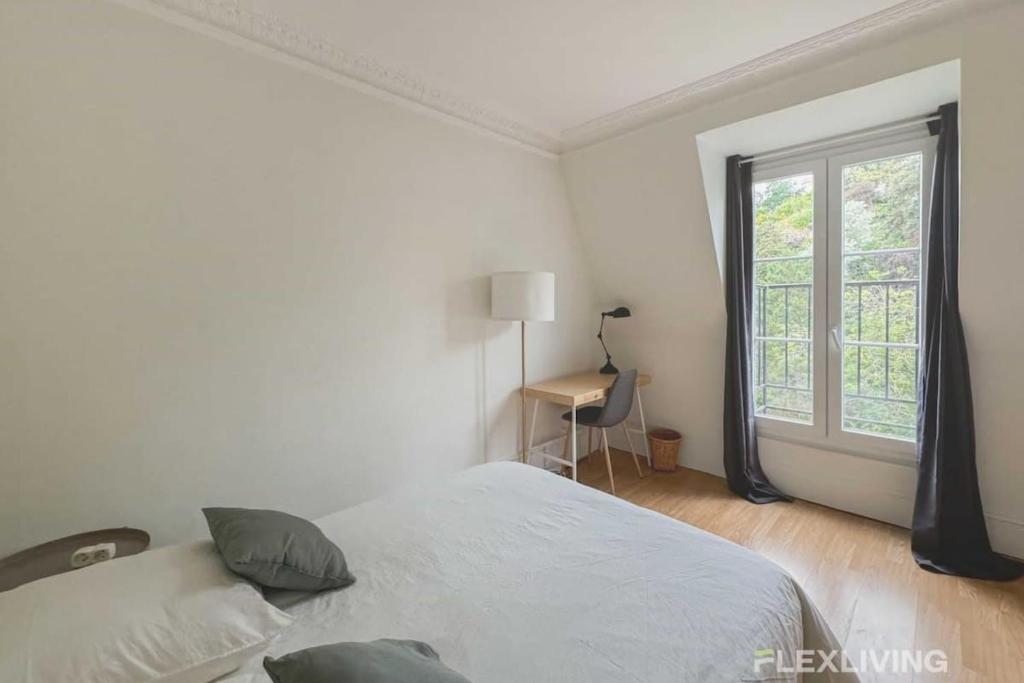 une chambre blanche avec un lit et une fenêtre dans l'établissement Flexliving - whole - Paris 18, à Paris