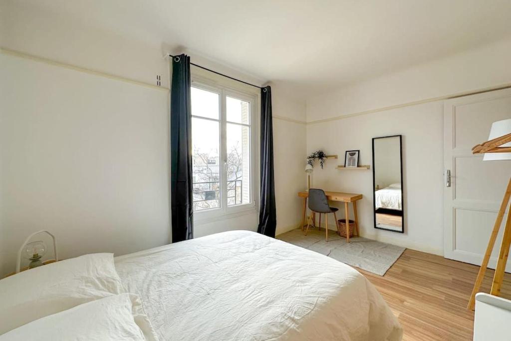 une chambre blanche avec un grand lit et une fenêtre dans l'établissement Flexliving - whole flate - Entrepreneur, à Paris