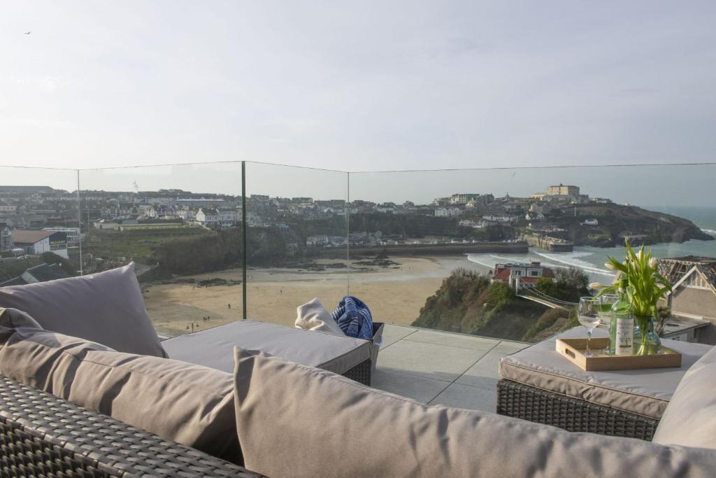 a living room with a couch and a view of a beach at 1 Island Reach in Newquay