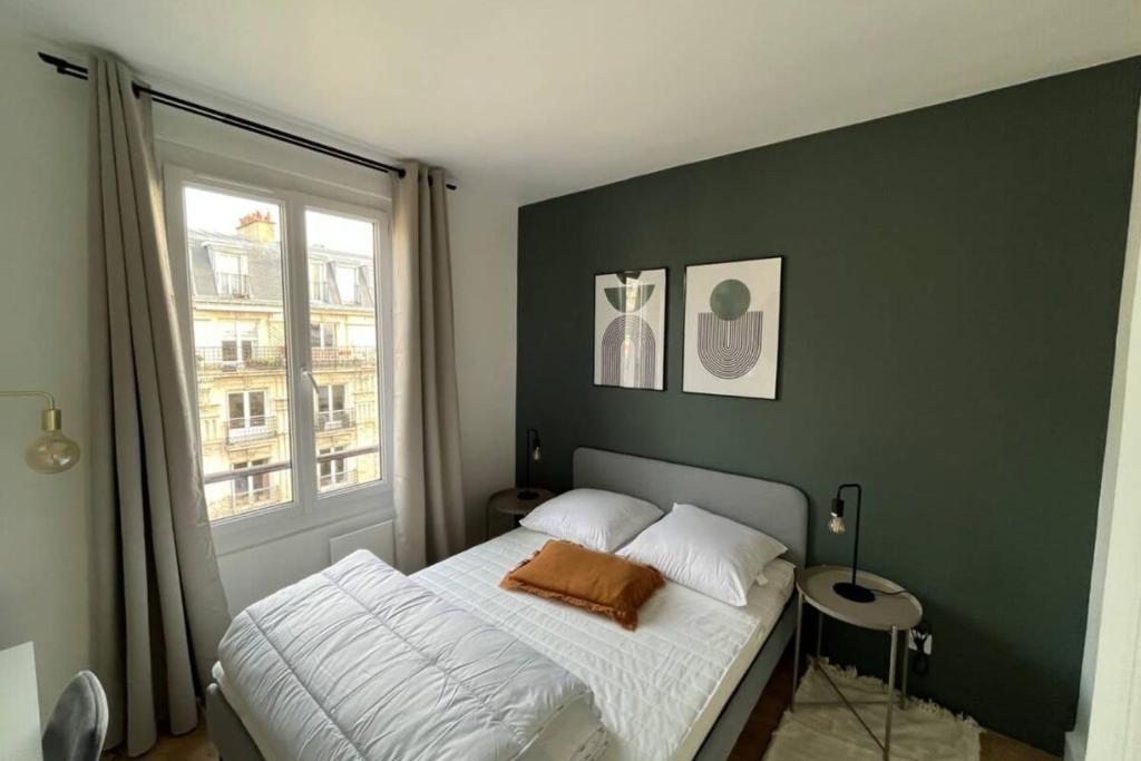 une chambre avec un lit et une fenêtre dans l'établissement Flexliving - Superb whole apartment - Caulaincourt, à Paris