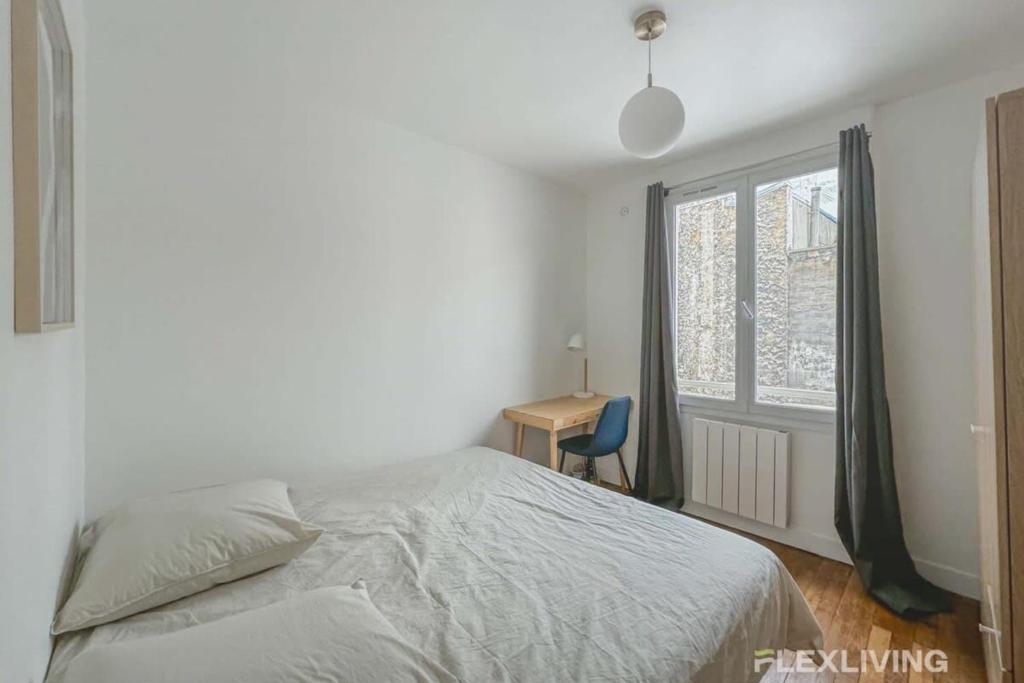 une chambre avec un lit, un bureau et une fenêtre dans l'établissement Flexliving - room - Saint Martin, à Paris