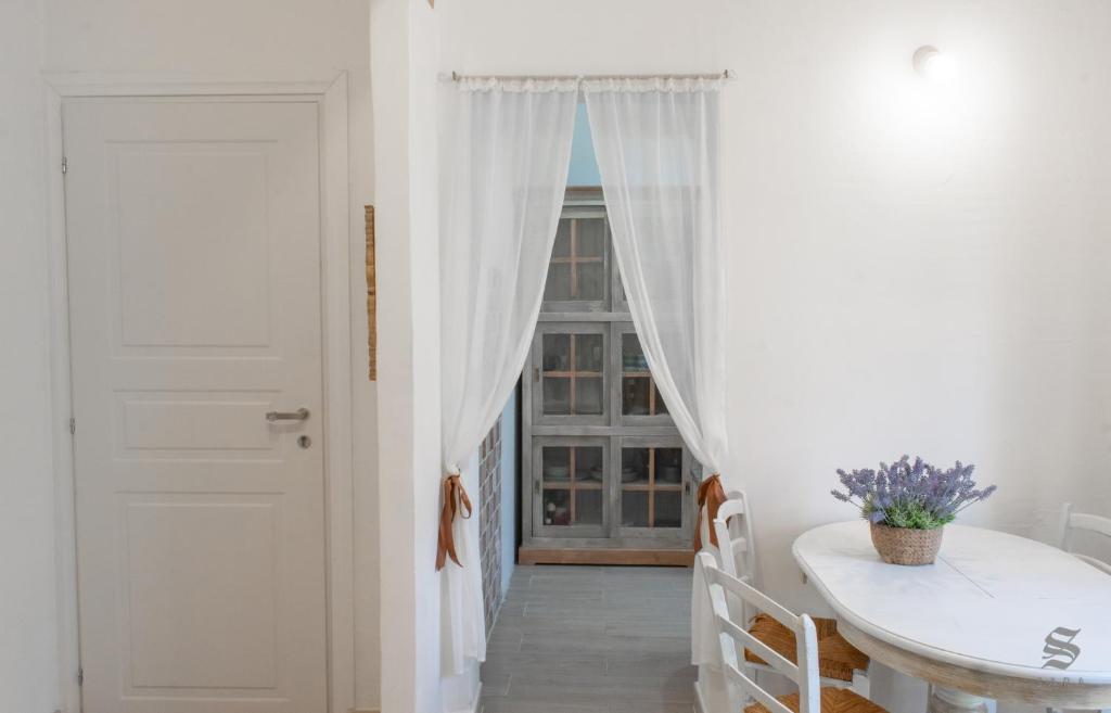 pasillo blanco con mesa y ventana en Sara's Apartment, en Arzachena