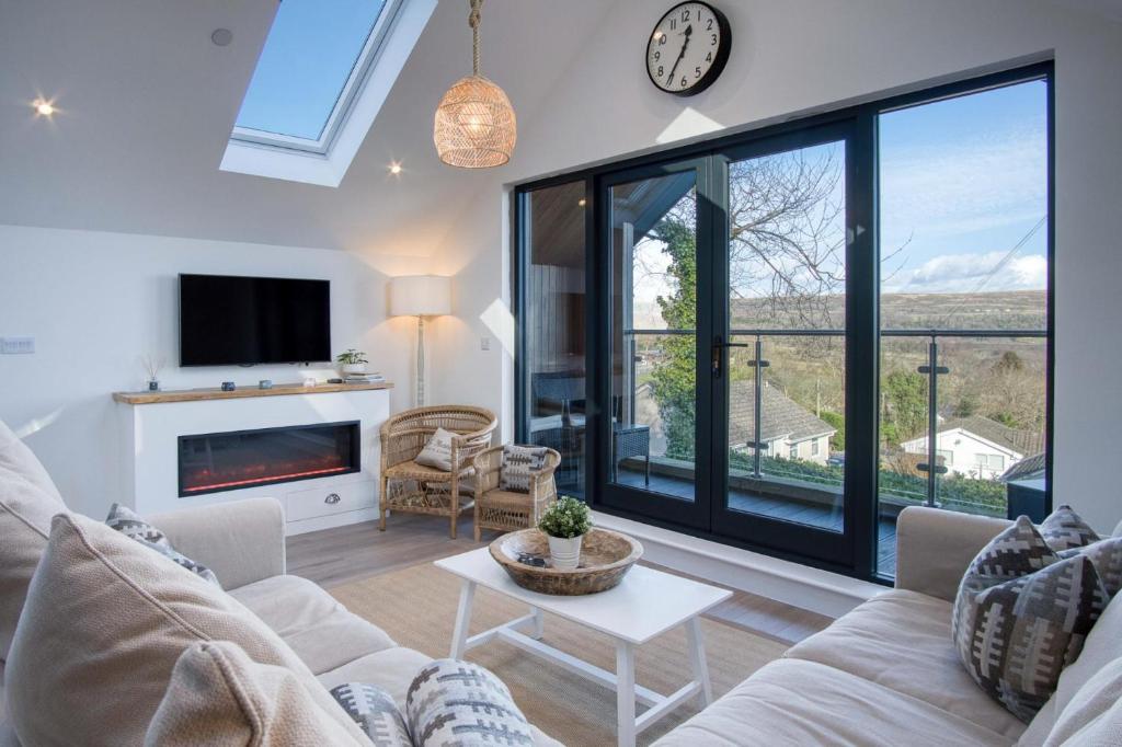 Ty Florence - 3 Bedroom Cottage - Bayview Oxwich في أوكسويتش: غرفة معيشة مع أريكة ونافذة كبيرة