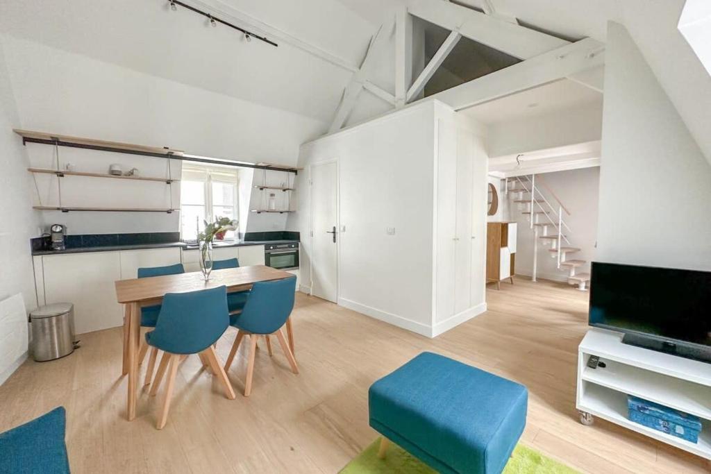 une cuisine avec une table à manger et des chaises bleues dans l'établissement Flexliving - appartement - Beauregard, à Paris