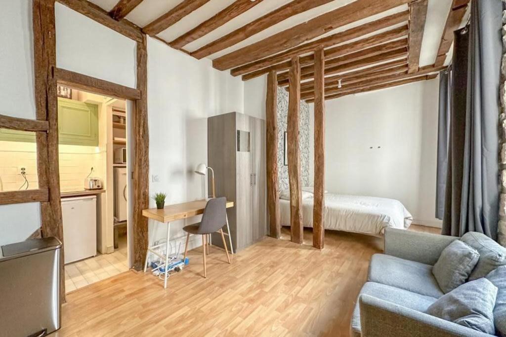 un salon avec un canapé, une table et un lit dans l'établissement Flexliving - Studio - Linné, à Paris