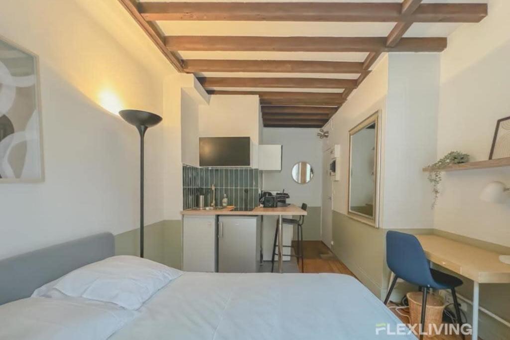 une chambre avec un lit et un bureau et une cuisine dans l'établissement Flexliving - Studio - Échiquier, à Paris