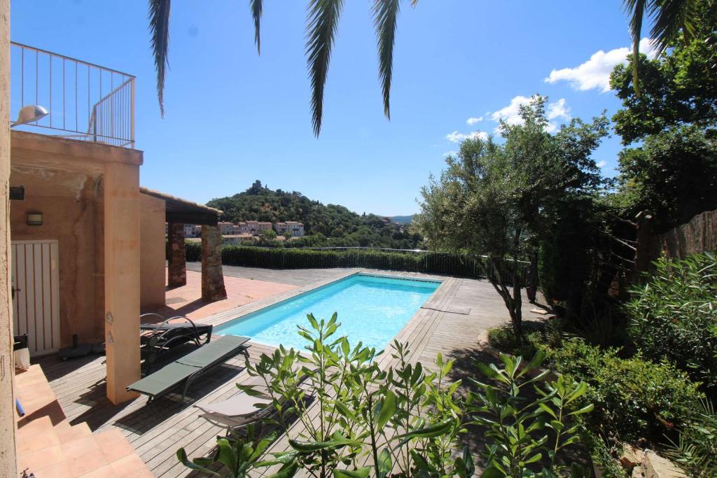 a swimming pool in front of a house at La Villa Tara 4 chambres piscine privée vue panoramique sur les collines de Grimaud in Grimaud