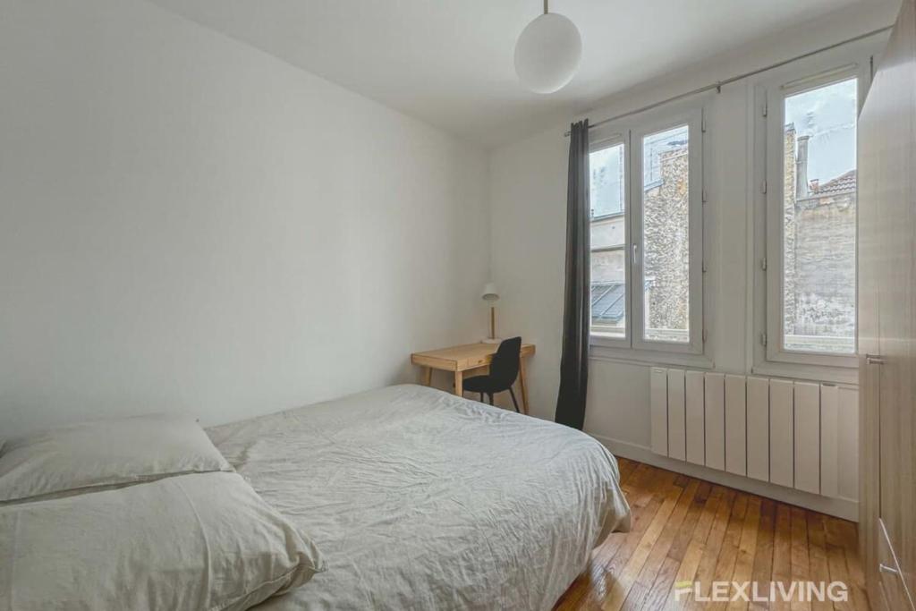 une chambre avec un lit, un bureau et des fenêtres dans l'établissement Flexliving - room - Saint Martin, à Paris