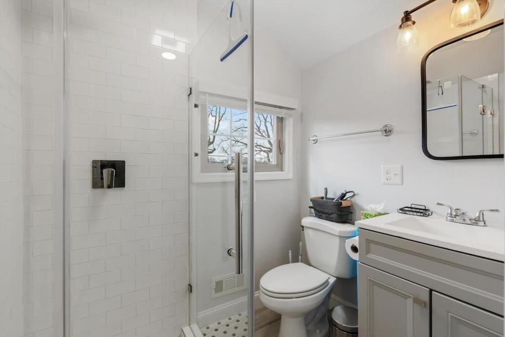 a white bathroom with a shower and a toilet at ALX Cape Cod 3-BR Near Old Town & Mount Vernon in Alexandria