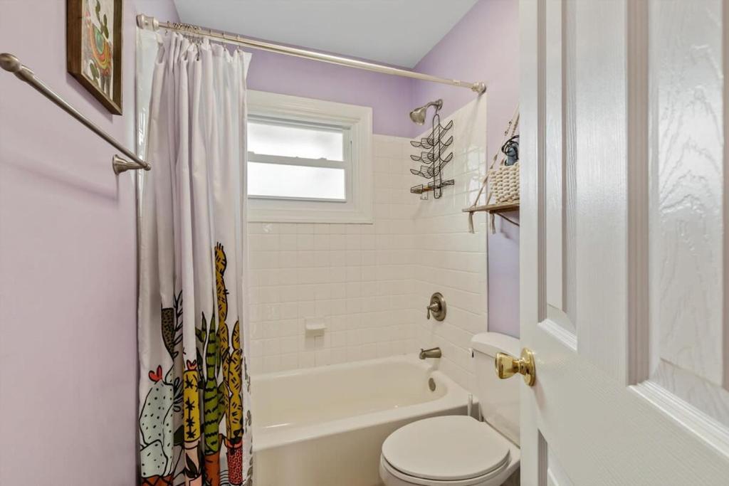 a white bathroom with a toilet and a bath tub at ALX Cape Cod 3-BR Near Old Town & Mount Vernon in Alexandria