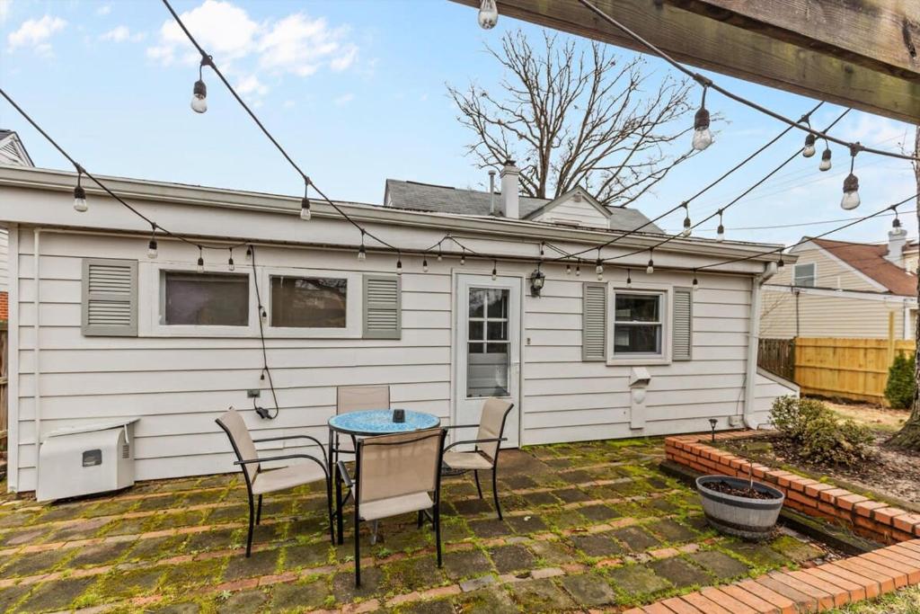 a patio with a table and chairs in front of a house at ALX Cape Cod 3-BR Near Old Town & Mount Vernon in Alexandria