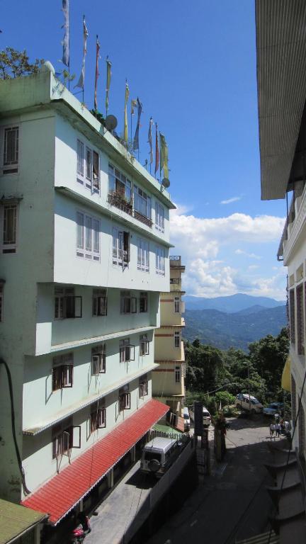 a tall building with flags on top of it at KG Tusheta - 200 mtrs from MG Marg in Gangtok