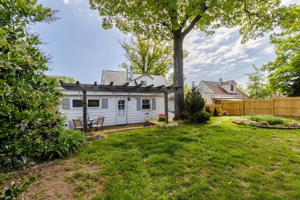 a yard with a white house and a fence at ALX Cape Cod 3-BR Near Old Town & Mount Vernon in Alexandria