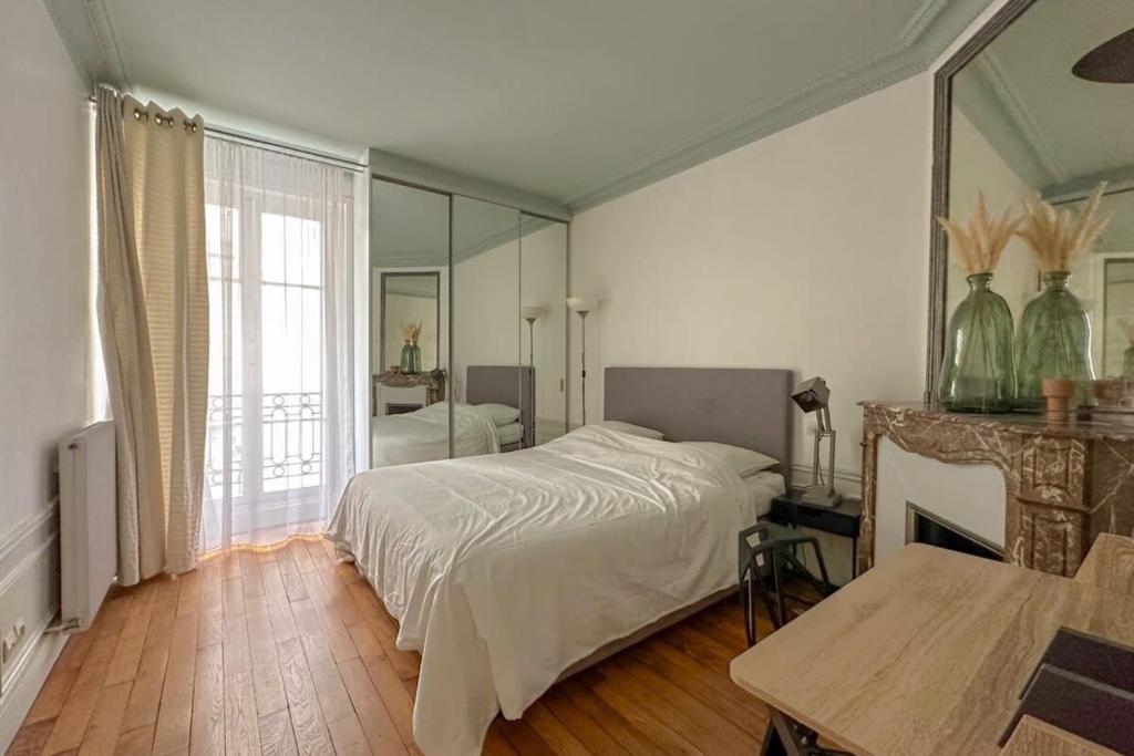 une chambre avec un lit et une grande fenêtre dans l'établissement Flexliving - whole flat - Bachaumont, à Paris