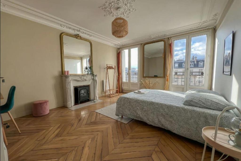 - une chambre avec un grand lit et une cheminée dans l'établissement Flexliving - whole flat - Voltaire, à Paris