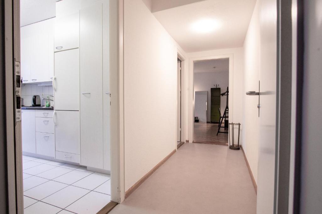 a hallway leading to a kitchen with white cabinets at Gemütliche Wohnung Nähe Uni in Basel