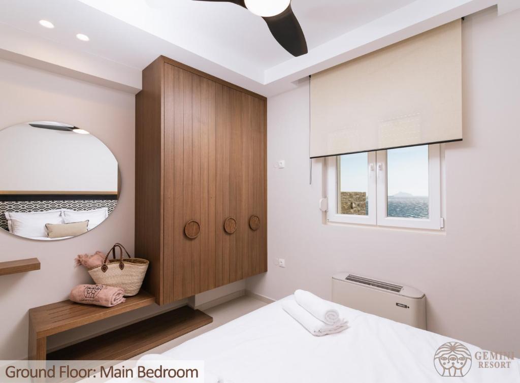 una camera con un grande specchio e un letto di Gemini Resort a Kalamaki