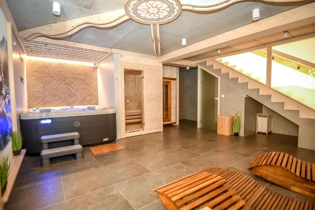 a large living room with a staircase and a tv at Apartamenty u Kurosa Jacuzzi & Sauna Ski Suche in Poronin