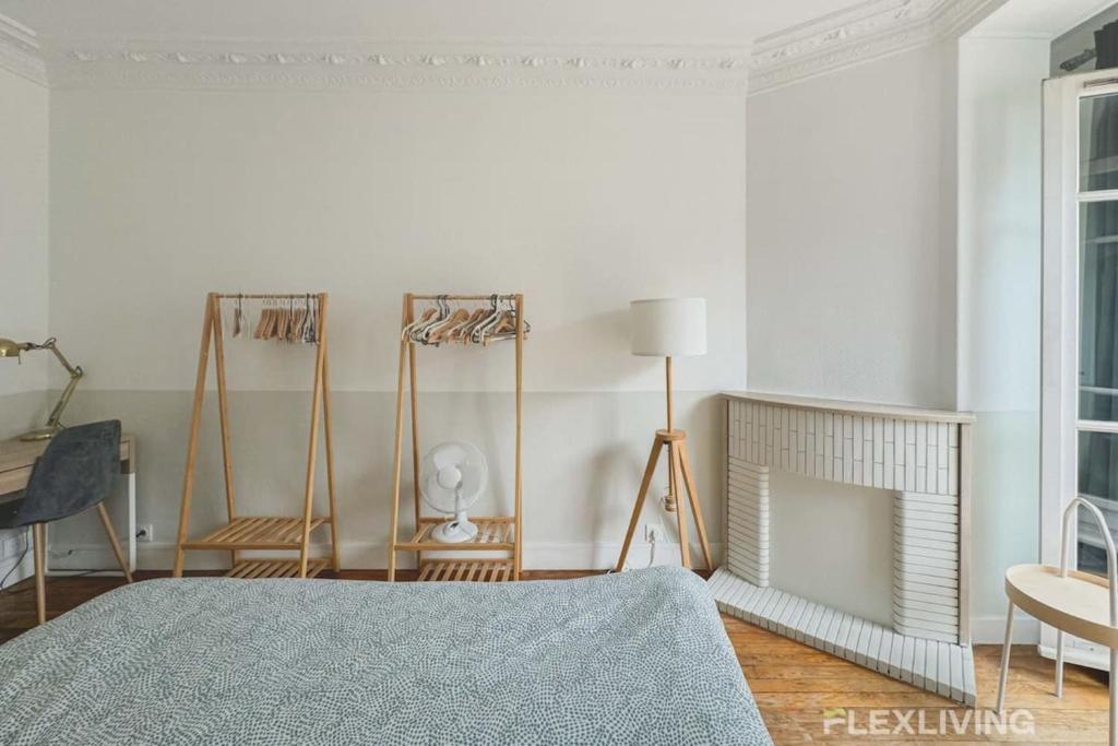- une chambre avec des murs blancs, un lit et une table dans l'établissement Flexliving - whole flat - Prague, à Paris