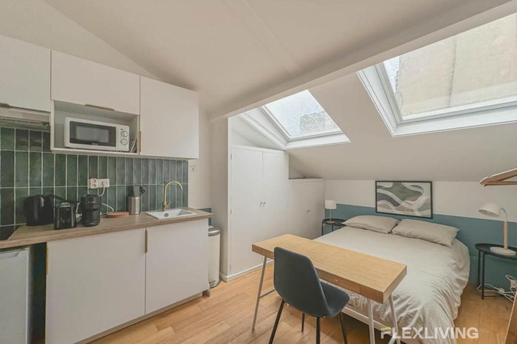 une cuisine et une chambre avec un lit et une table dans l'établissement Flexliving - Studio - St Dominique, à Paris
