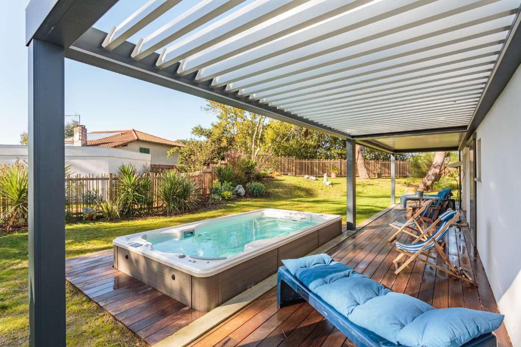 une terrasse en bois avec un bain à remous. dans l'établissement BALEA Grand appartement avec SPA de Nage au cœur de Chiberta, à Anglet