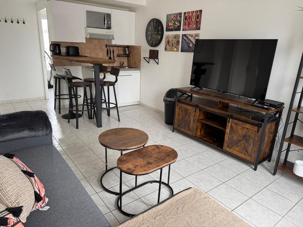 un salon avec une télévision, une table et un tabouret dans l'établissement Appartement moderne cosy récent, à Marly-la-Ville