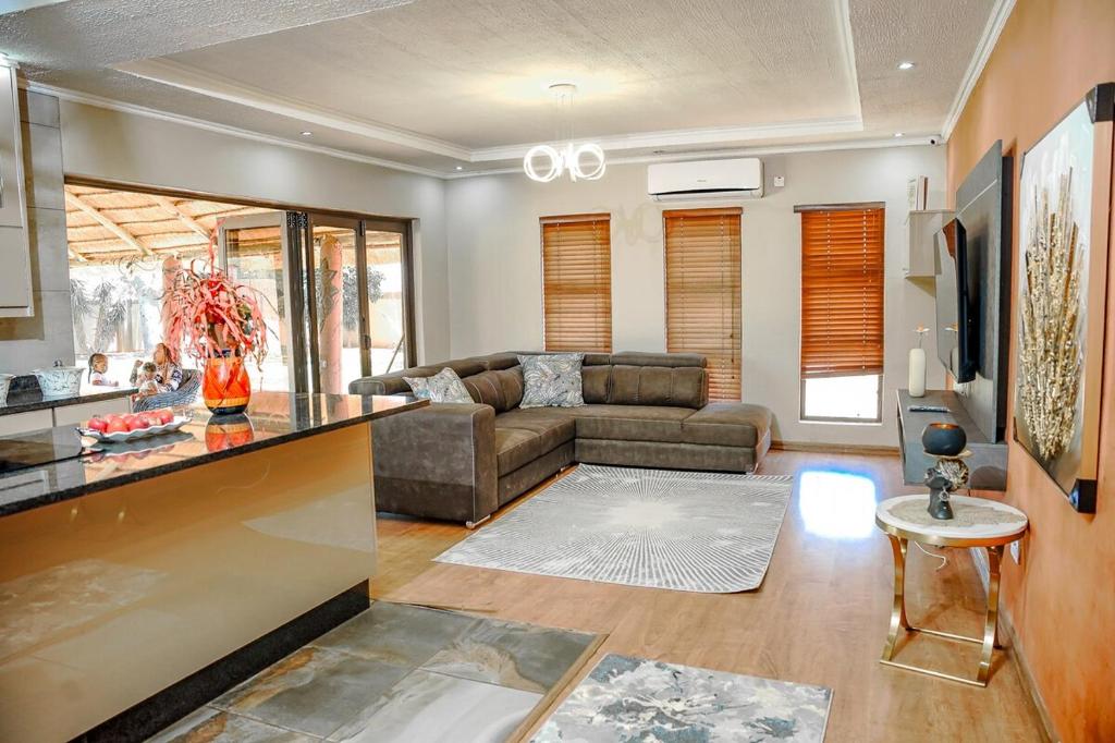 a living room with a couch and a table at Laicah House in Tlokweng