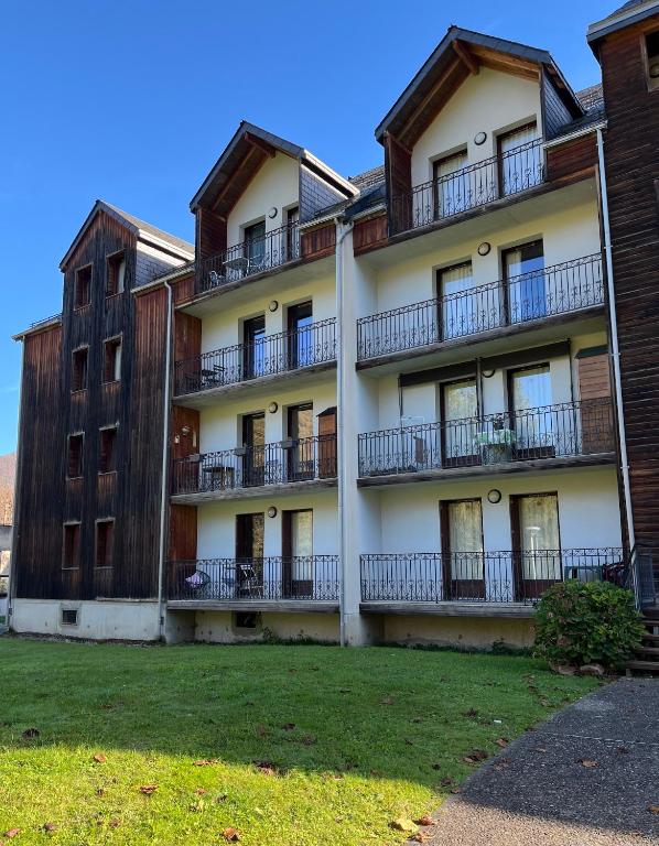 un immeuble d'appartements avec balcon et cour dans l'établissement Bagnères-de-Luchon T3, à Luchon