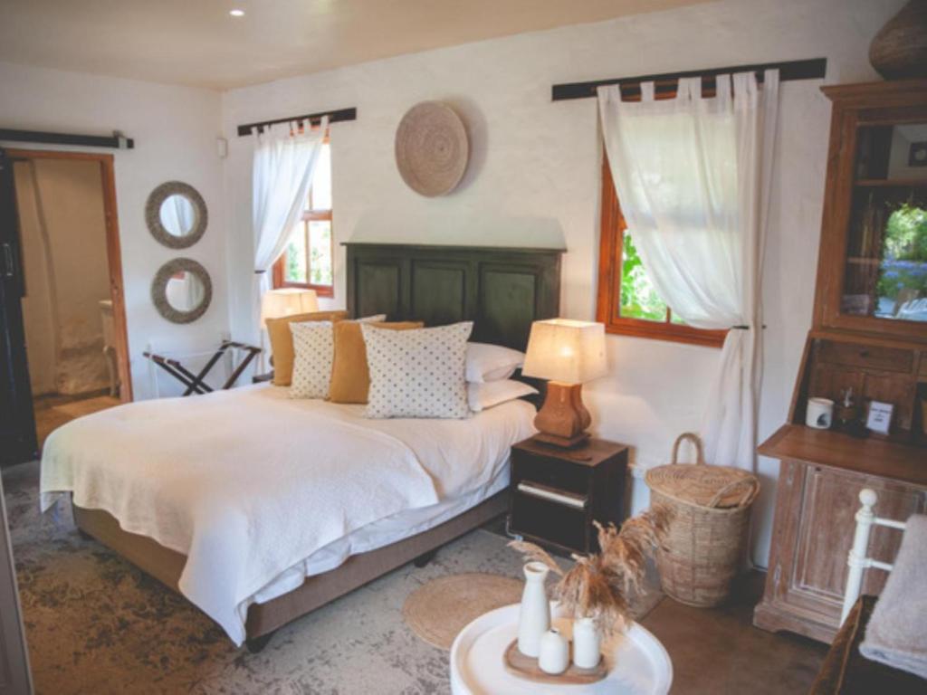 a bedroom with a bed and a table with a lamp at Croxley Farm in Robertson