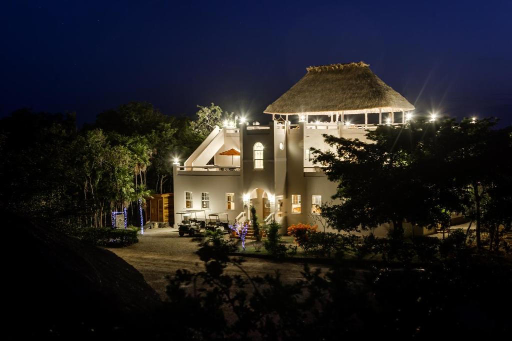 a large white building with a thatched roof at night at The Crimson Orchid Inn in San Fernando