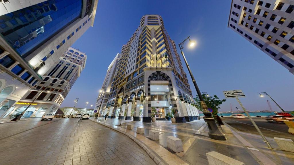 a tall building on a street in a city at Al Muna Kareem Hotel- EX LEADER in Medina