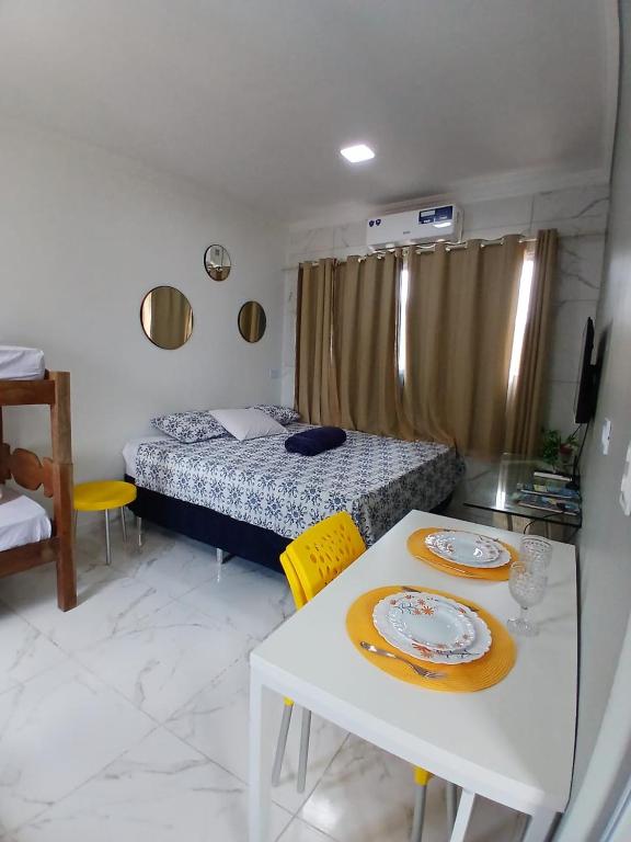 a room with a bed and a table with plates on it at Recife e Olinda - Studio Bastos Residence in Recife