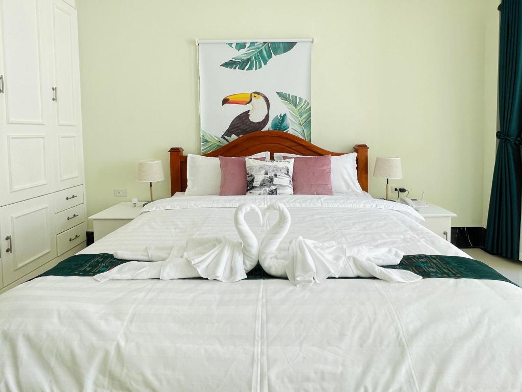 a white bed with two white swans on it at Vanida Hotel in Vientiane