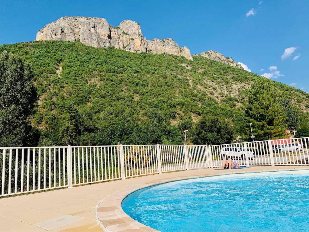 une clôture avec une piscine en face d'une montagne dans l'établissement Apt F2 proche centre thermal, à Digne-Les-Bains