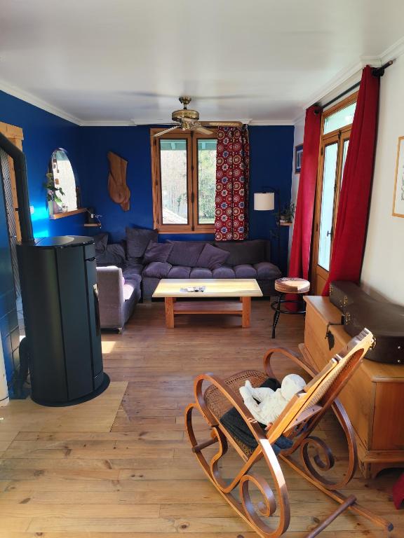 un salon avec un canapé et une télévision dans l'établissement Petite chambre, à Aigueblanche