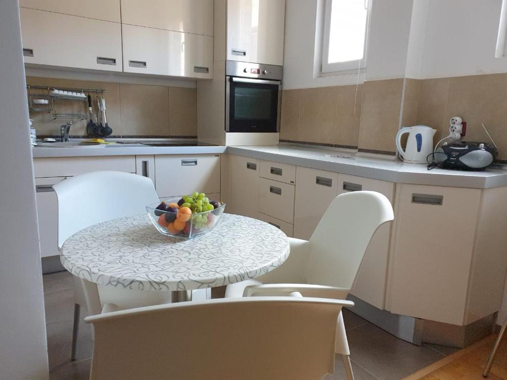 a kitchen with a table with a bowl of fruit on it at Victor Apartments in Petrovac na Moru