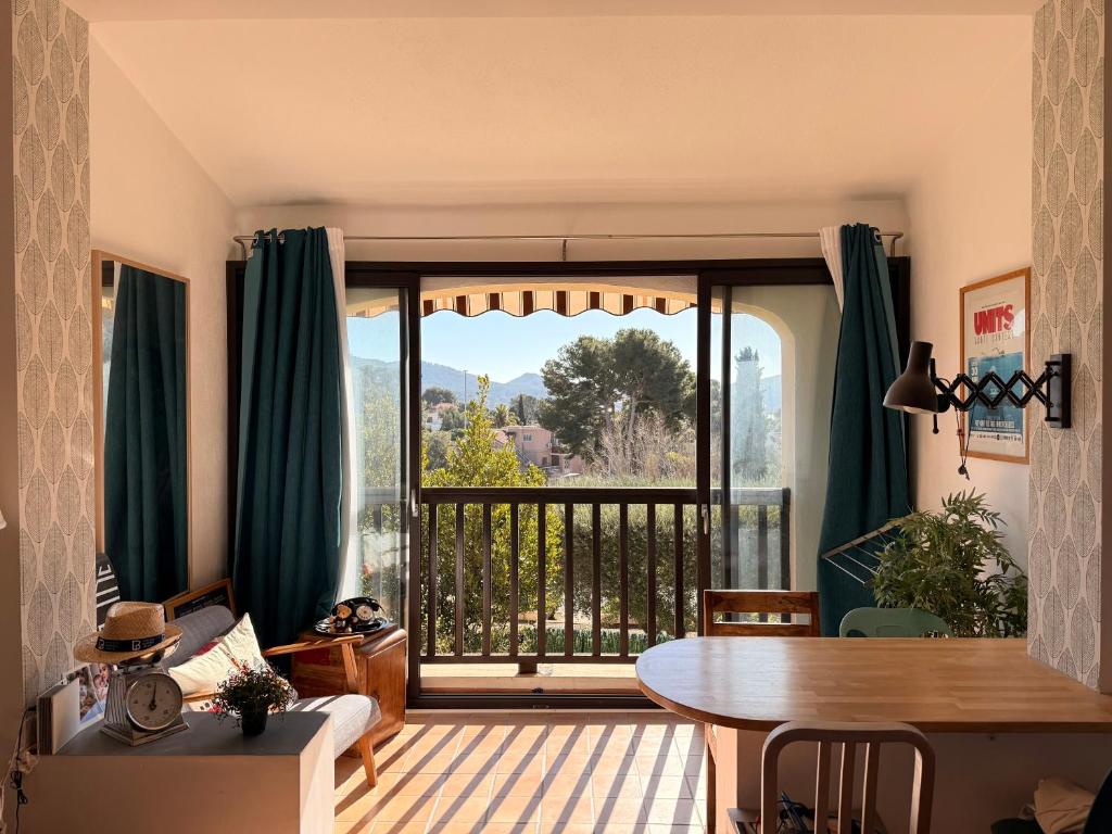 un salon avec une table et une grande fenêtre dans l'établissement Appartement avec mezzanine de vacances à 7 min de la plage, aux Lecques